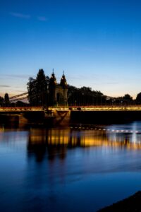 Hammersmith Bridge illuminated at dusk over the River Thames in London