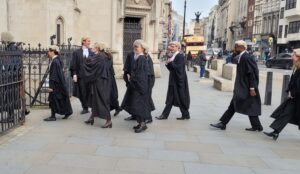 Barristers in wigs and gowns outside the Royal Courts of Justice on the Strand, London