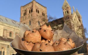 Hot cross buns in a bowl with St Albans Cathedral in the background, Hertfordshire