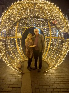Alison and her husband David standing inside a giant illuminated Christmas bauble in St Albans.