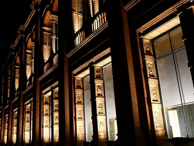 Window arches of the Victoria and Albert Museum at night.