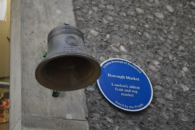 Borough Market bell with blue shield describing it as Londons oldest fruit and veg market.