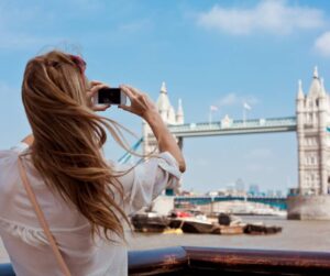 Female tourist taking a photo of Tower Bridge in London