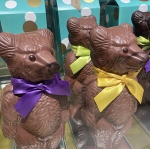 Milk chocolate bears decorated with colourful ribbon bows in a London chocolate shop.